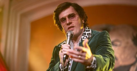 Hlavný hrdina z filmu Duchoň smieva do kamery s mikrofónom v ruke