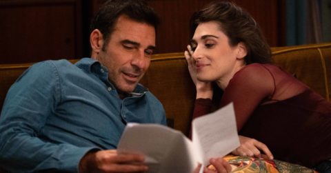 Hlavné postavy filmu Bláznivo (Genovese, 2025) ležia vedľa seba na gauči a čítajú si