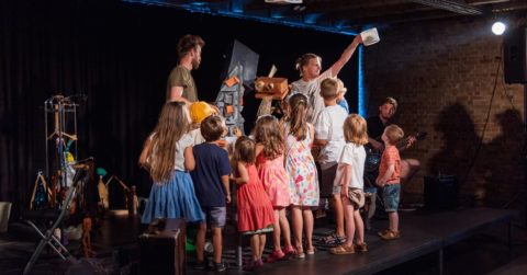 Deti v divadle obkolesujú režiséera a herca Petra Gartnera