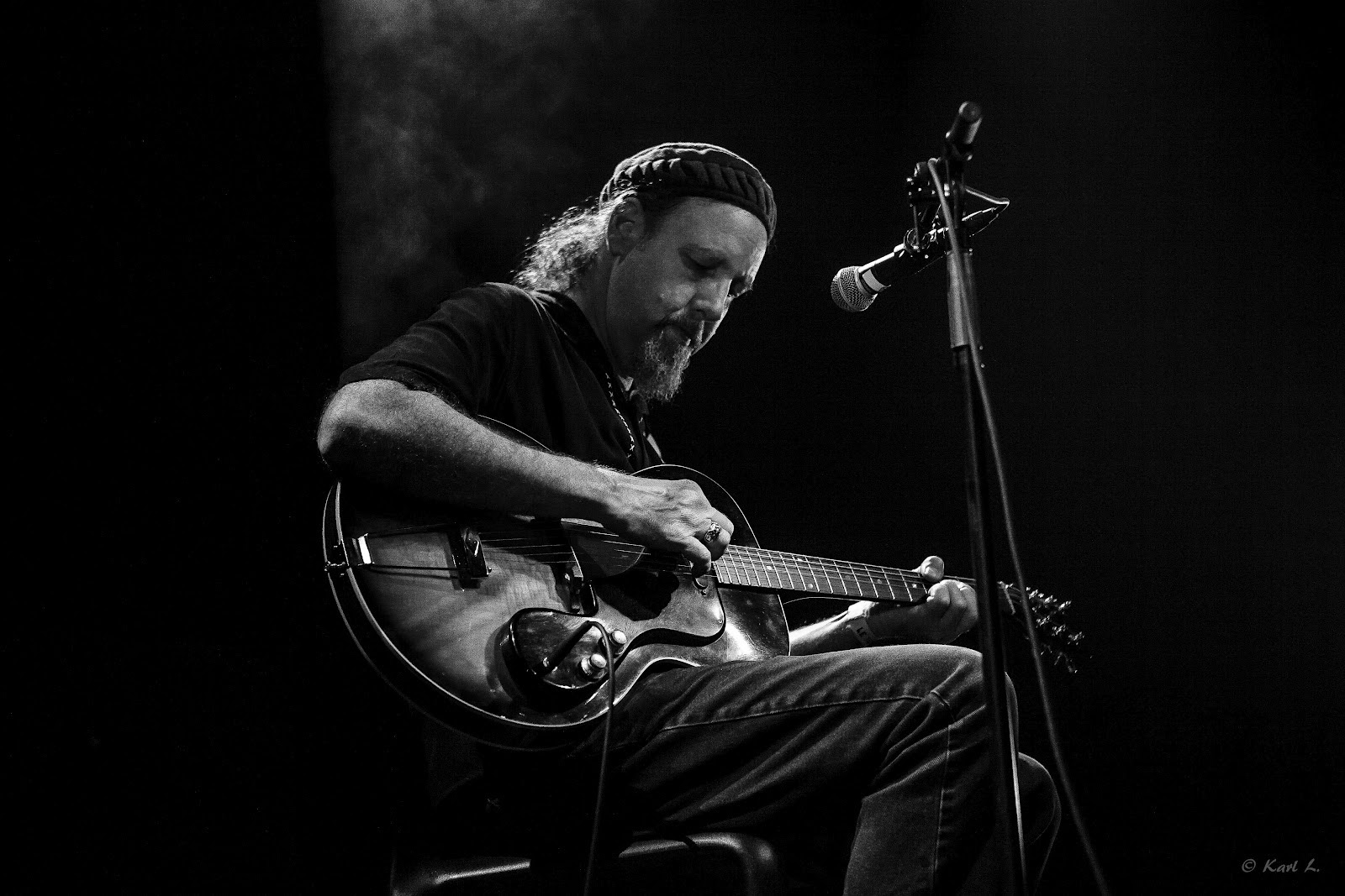 Sir Richard Bishop na pódiu s gitarou a mikrofónom